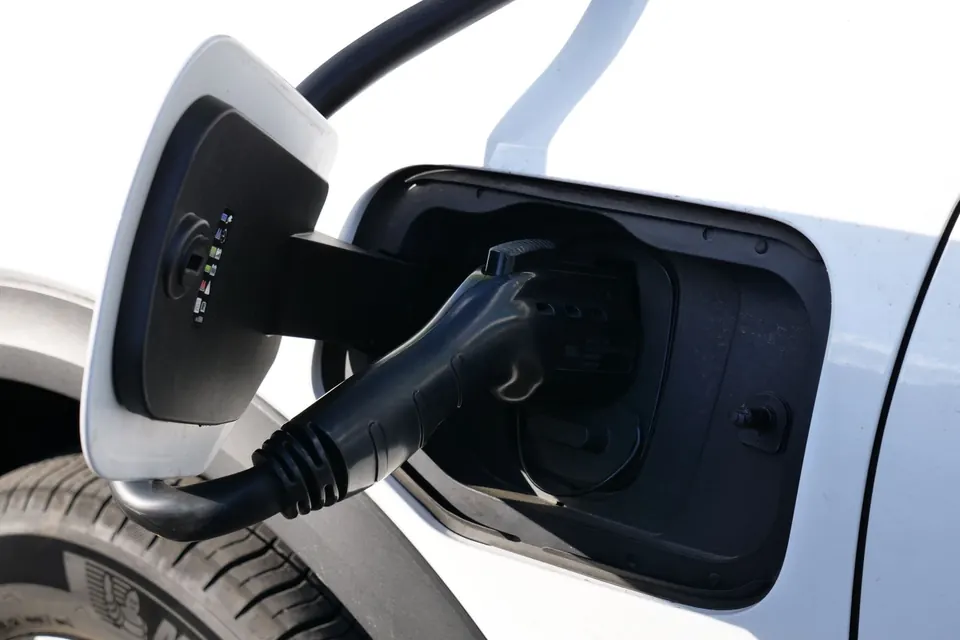 Close-up view of an electric vehicle charging with a focus on the connector and charging port.